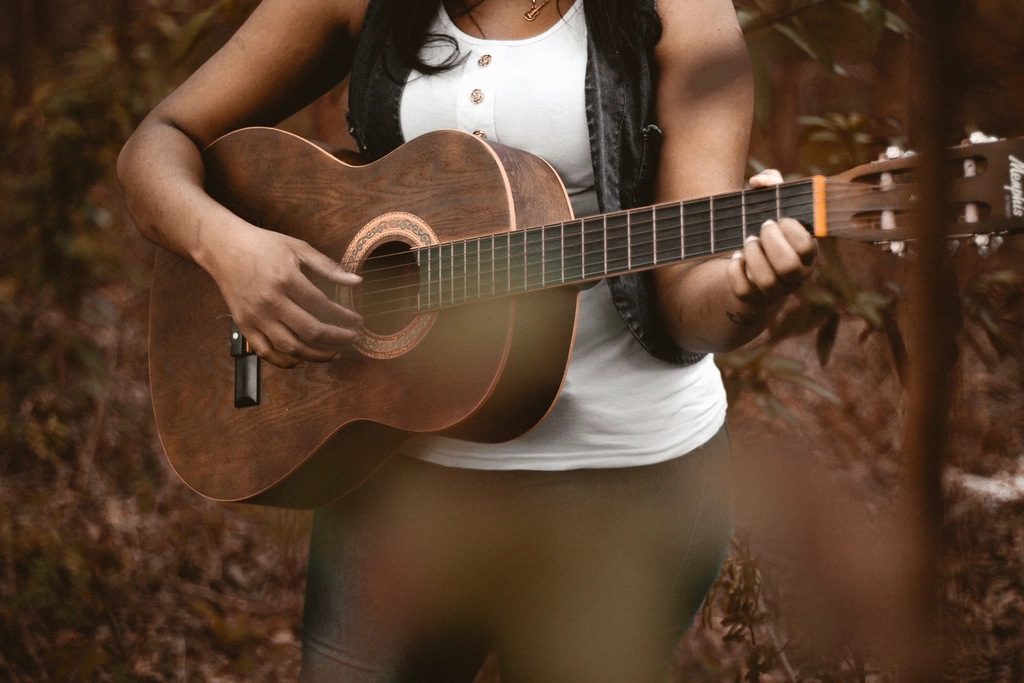 A woman playing guitar outdoors